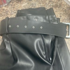 Faux leather pants with pleats, and a belt.